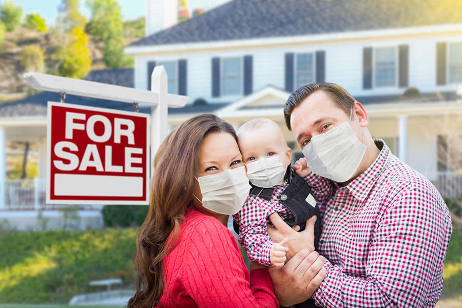 Family wearing masks in front of a house for sale during COVID
